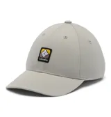 Gorra Columbia Twin Canyon Ball Cap color gris, con visera curva, ojales bordados para ventilación y un parche frontal cuadrado con el logo de la marca en negro, amarillo, marrón y blanco.