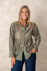 Camisa de manga larga en color verde oliva, confeccionada en tejido semitransparente con diseño bordado en hilo de seda con motivos circulares. Presenta cuello clásico, cierre frontal con botones y corte holgado.