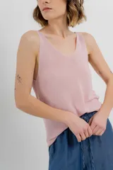 Musculosa tejida color amarillo pálido, con escote en V delantero y trasero.