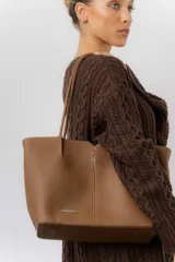 Cartera tipo tote de diseño amplio y estructurado, confeccionada en material sintético con textura graneada. Cuenta con doble asa larga para llevar al hombro y un compartimento principal espacioso.