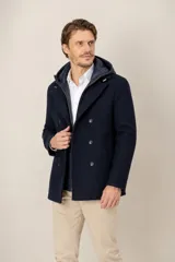 Campera de paño azul marino con diseño de doble abotonadura, que incluye un chaleco interior acolchado con capucha de nylon desmontable.