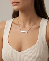 Collar de cadena fina con dije de barrita rectangular lisa de acero, ideal para grabado personalizado.