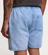 Bermuda de jeans de hombre, color negro con efecto desgastado o acid wash, de corte holgado. Posee cintura elástica con cordón de ajuste y bolsillos laterales.