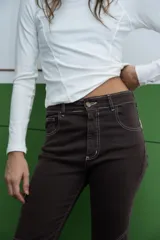 Jean de corte acampanado en color negro, con diseño de tiro medio y bajo deshilachado.
