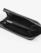 Billetera rectangular con cierre perimetral, confeccionada en cuero vegano con textura de piel de serpiente en color negro.