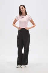 Remera cropped de color rosado con cuello redondo y detalles de costuras en color marrón. Presenta un bordado frontal con el número 94 y estrellas.