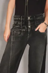 Jean de corte tomboy en color negro con efecto lavado, diseño de tiro alto con doble botón frontal y costuras verticales decorativas en los laterales.