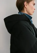 Campera puffer negra con capucha, cuello alto y cierre frontal de cremallera doble. Diseño acolchado de manga larga con acabado repelente al agua.