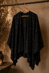 Ruana negra con sutil hilo lurex brillante, de diseño amplio y abierto.