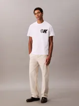 Remera de algodón regenerativo Calvin Klein de corte regular, color blanco, con cuello redondo y mangas cortas. Presenta un estampado gráfico con el monograma de la marca en contraste sobre el pecho.