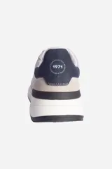 Zapatillas urbanas de hombre, color gris claro con detalles en azul y beige. Fabricadas en cuero y nylon, con suela de goma.