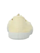 Zapatillas de lona color amarillo claro, con suela y puntera de goma blanca, ojalillos metálicos y diseño ligero sin cordones.