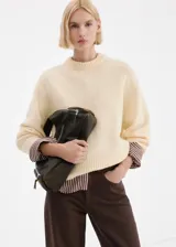 Jeans rectos tiro medio color marrón oscuro con bolsillos clásicos y cierre frontal.