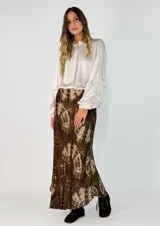 Pollera midi de corte al bies con estampado tie-dye en tonos marrones y beige. Confeccionada en tela fluida con caída suave.