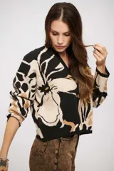 Saco tejido de punto con diseño animal print abstracto en tonos negro, beige y tostado. Presenta escote en V, cierre frontal con botones y mangas largas con puños ajustados.