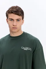 Remera boxy de color beige, de manga corta, con estampa en la espalda inspirada en código de programación y estética digital.