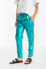 Pantalón de lino metalizado color turquesa, con cintura elástica, corte pitillo, bolsillos laterales y traseros.