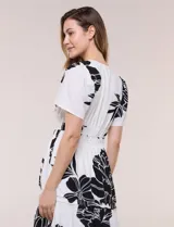 Vestido midi de seda fría con estampado floral en blanco y negro, cuello en V y mangas cortas acampanadas. Cuenta con cintura elastizada y falda evasé con volado en el ruedo.
