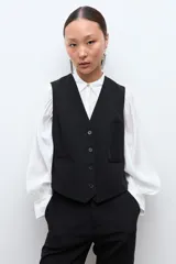 Chaleco sastrero de corte clásico, color negro, con cierre frontal de cuatro botones y escote en V.