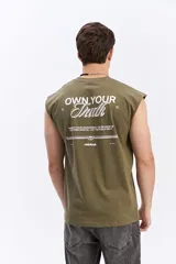 Musculosa oversize de algodón color verde militar, con corte amplio, mangas abiertas y estampa tipográfica en la espalda.