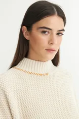 Buzo color verde oliva de punto con cuello alto, mangas largas y calce oversize.