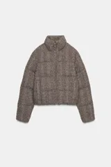 Anorak estilo bomber con diseño acolchado y tejido de punto con textura. Presenta cuello subido, cierre frontal con cremallera, mangas largas con elástico interior y bolsillos delanteros de vivo con forro polar. El bajo cuenta con acabado elástico.