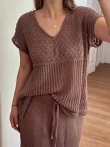 Remera color marrón de hilo de algodón con punto calado, escote en V, manga corta, silueta oversize y tajos laterales.