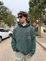 Buzo canguro oversize de algodón, color azul oscuro, con capucha y diseño gráfico circular estampado en la espalda con la inscripción VCP CONCEPTS STUDIO.