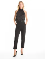 Pantalón de crepe marca Zac & Rachel, color negro, de corte recto y entallado, con largo hasta el tobillo. Presenta pretina con detalles en cuero sintético, pasadores funcionales, cierre con broche interno y bolsillos aplicados en la parte delantera.
