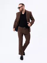 Traje slim color marrón de dos piezas, compuesto por un saco entallado de dos botones y un pantalón de corte recto. Confeccionado en mezcla de lana y poliéster.