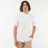 Camisa blanca de manga corta y cuello mao, con cierre frontal de botones con efecto carey y diseño en mezcla de lino.