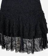 Short pollera negro de encaje con textura, cintura elástica y doble capa de volados.