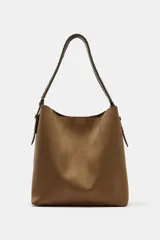 Bolso de hombro formato saca en color marrón, con asa superior trenzada y cierre mediante clip metálico. Incluye compartimento interior extraíble con cremallera.