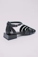 Sandalias de cuero estilo jaula en color rojo, con punta cuadrada, taco cuadrado bajo en color negro y cierre con hebilla ajustable en el tobillo.