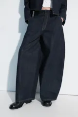 Jeans de tiro medio con diseño balloon fit, color azul oscuro, bolsillos laterales y costuras marcadas. Cuenta con cierre frontal.