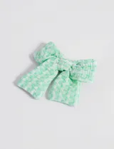 Broche para el pelo con forma de moña a cuadros color verde y blanco.