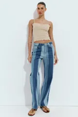 Jeans de tiro medio y pernera recta con diseño de rayas verticales en diferentes tonos de denim. Cuenta con cinco bolsillos y cierre frontal con cremallera y botón.