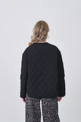 Campera acolchada de diseño capitoneado con patrón de rombos, color negro, de corte holgado, manga larga y cierre frontal con botones a presión.