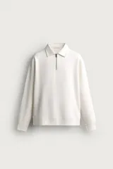 Sudadera polo de corte regular, confeccionada en tejido técnico interlock de algodón con elasticidad. Presenta cuello solapa, cierre frontal de cremallera y manga larga con puños acabados en rib.