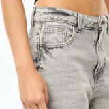 Pantalón de jean gris claro, corte recto, tiro medio y ruedo con dobladillo.