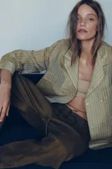 Pantalón tipo baggy de tiro bajo, confeccionado en mezcla de lino. Presenta cintura elástica con cordón ajustable, cierre frontal con botones y falsos bolsillos de vivo en los laterales.