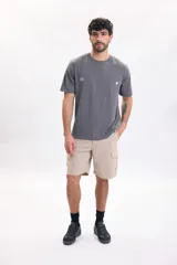 Remera gris oscuro de manga corta, con estampa tipográfica grande en la espalda con el texto 'Tropical Sunsets & Peaceful Waves'.