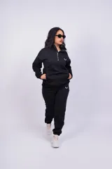 Pantalón de jogging color beige con cintura elástica y logo estampado en blanco en el muslo.