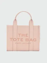 Cartera tipo tote de cuero granulado negro con diseño estructurado. Presenta el logo 'THE TOTE BAG' grabado en el frente, doble asa superior y correa ajustable extraíble. Incluye herrajes metálicos dorados.