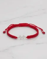Pulsera de hilo rojo tejida en macramé con dijes de plata 925 en forma de niño y niña, con terminaciones ajustables decoradas con esferas de plata.
