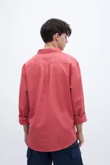 Camisa celeste de algodón, corte regular fit, con cuello solapa clásico, manga larga, bolsillo en el pecho y botones personalizados.