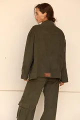 Pantalón jean cargo de pana color verde militar, de pierna súper ancha y tiro alto. Presenta bolsillos laterales.