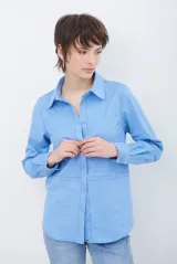 Camisa de estilo casual confeccionada en material tipo gamuza color marrón, con cuello clásico, cierre frontal con botones y costuras a la vista en tono contrastante.