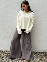 Sweater de tejido bremer color marrón, con cuello polo y cierre frontal parcial, de manga larga y diseño holgado.