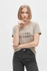 Remera de algodón color gris taupe, con cuello en V, manga corta, corte al cuerpo y estampa frontal con la inscripción "LOCAL CELEBRITY".